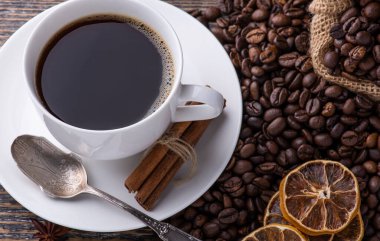 Beyaz seramik bardak aromatik taze demlenmiş sıcak içecek kahve çekirdeği arka planında, boşluğu kopyala.