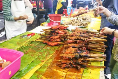 Pazar tezgahları ramazan boyunca iftar veya buka puasa için satılan ayam percik denilen popüler Malezya mutfağı