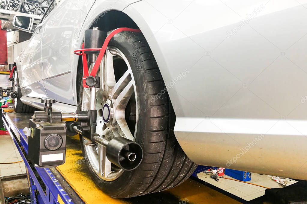 Car undergo wheel align in garage with precision alignment equipment