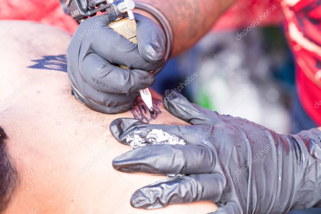 Closeup of tattoo grafting drawing onto body using tools and equipment