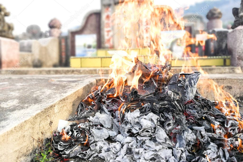 Chinese with taoism belief offers the deceased with burning of paper money and other offerings during qingming festival in Malaysia