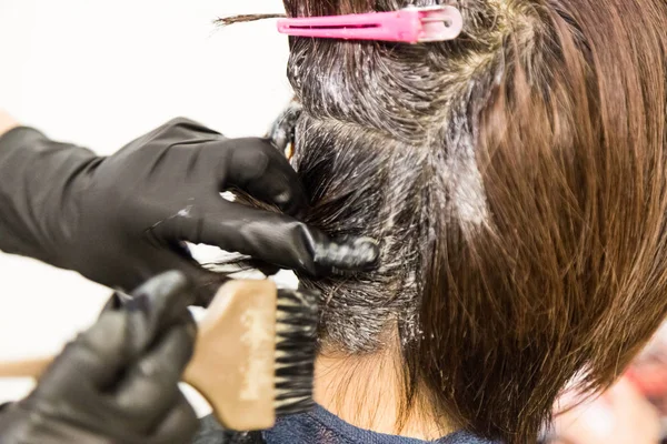 サロンでお客様の髪に化学染料を適用するアリスヘア ドレッサーのクローズ アップ — ストック写真