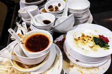 Kirli ve yağlı tabaklar, kaseler ve yemekten sonra aletleri yığını