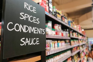 Rice, spices, condiments, sauces signage grocery categoy aisle at supermarket clipart