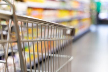 Alışveriş arabası sepeti ile modern süpermarket koridor karşı sığ Dof arka plan bulanık