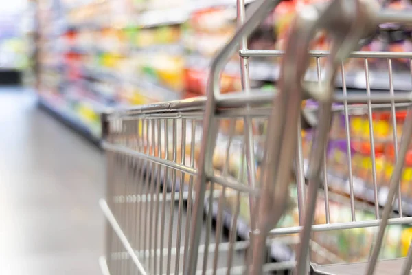 Einkaufswagen Mit Seichtem Dof Vor Modernem Supermarkt Gang Verschwommener Hintergrund — Stockfoto