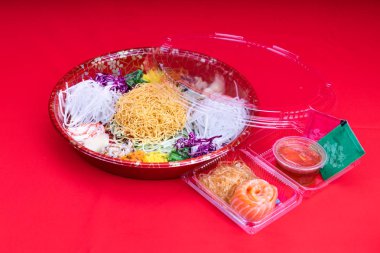 Yee Sang veya Yusheng kolaylık sağlamak için kapsayıcı bir paket servisi olan restoran hizmet. Çin yeni yılı sırasında iyi şans getirdiğine inanılan çubuklarla savurma tarafından alınan.