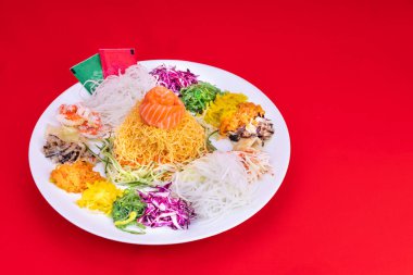 Yee Sang veya Yusheng porsiyon şans getirdiğine inanılan. Çin yeni yılı sırasında çubuklarla savurma tarafından alınan