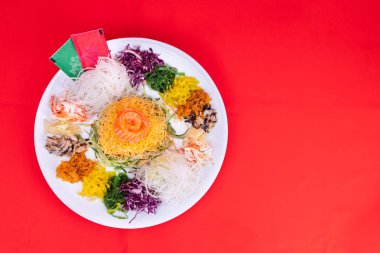 Yee Sang veya Yusheng porsiyon şans getirdiğine inanılan. Çin yeni yılı sırasında çubuklarla savurma tarafından alınan