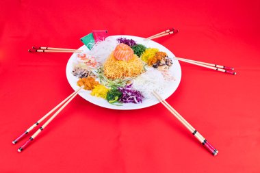 Yee Sang veya Yusheng porsiyon şans getirdiğine inanılan. Çin yeni yılı sırasında çubuklarla savurma tarafından alınan