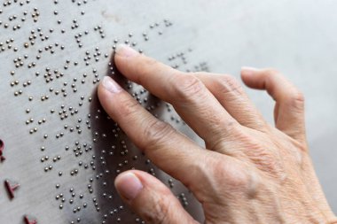 Finger reading braille tactile on public park message board in Hong Kong clipart