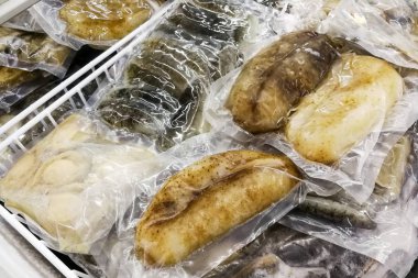 Frozen fresh abalone and sea cucumber, packaged for retail clipart