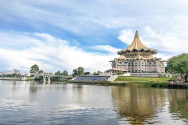 Kuching, Malezya, 18 Nisan 2019: Sarawak Nehri üzerindeki Darul Hana köprüsü Sarawak Eyalet Meclis Binası'nı denetleyerek Kuching'in popüler turizm merkezidir..