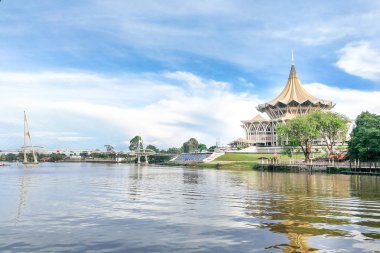 Kuching, Malezya, 18 Nisan 2019: Sarawak Nehri üzerindeki Darul Hana köprüsü Sarawak Eyalet Meclis Binası'nı denetleyerek Kuching'in popüler turizm merkezidir..