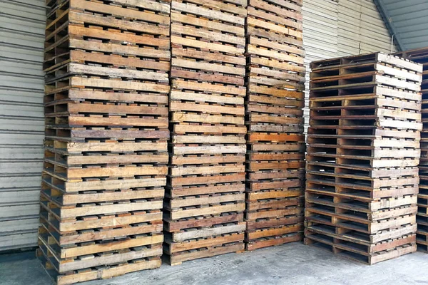 Montón de paletas de madera en el almacén. Transporte negocio logístico — Foto de Stock