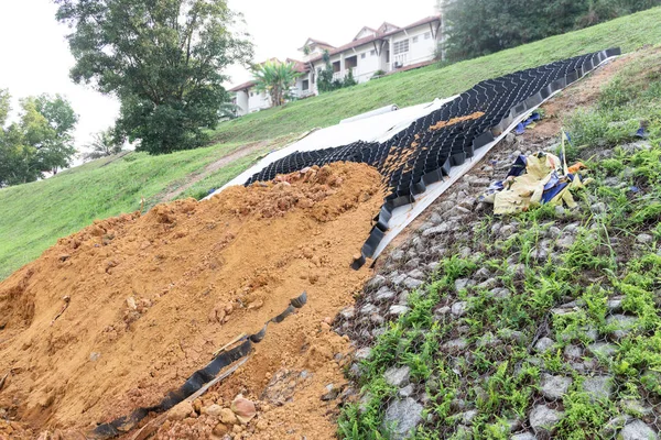 Slope erosion control grids, sheets and earth on steep slope — Stock Photo, Image