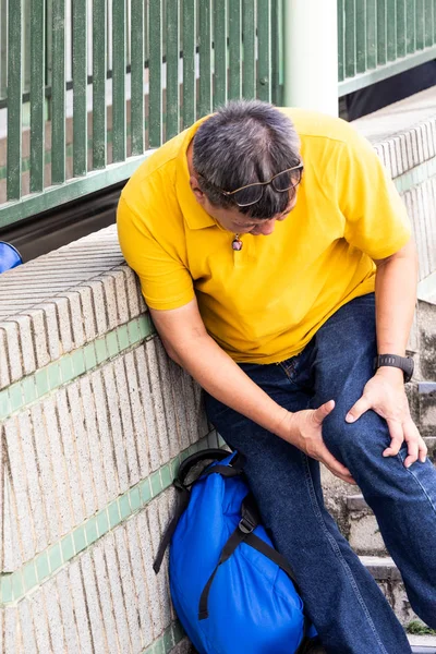 痛みを伴う膝の苦労を持つ男は、階段の飛行を歩いて — ストック写真