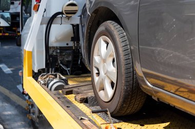 Düz yataklı çekicinin üzerinde kırık araba tamir için taşınıyor