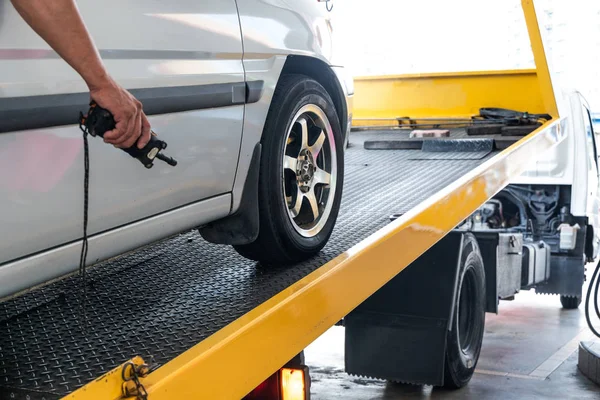 Closeup on car towed onto flatbed tow truck with cable — Stock Photo, Image