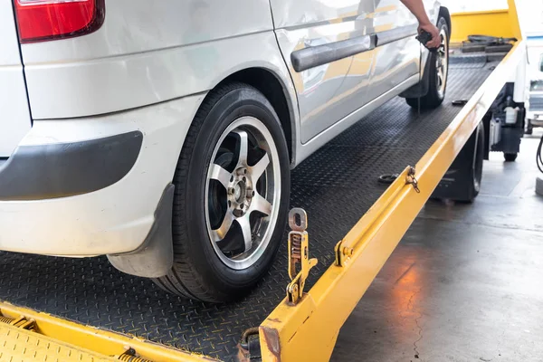 Closeup on car towed onto flatbed tow truck with cable — Stock Photo, Image