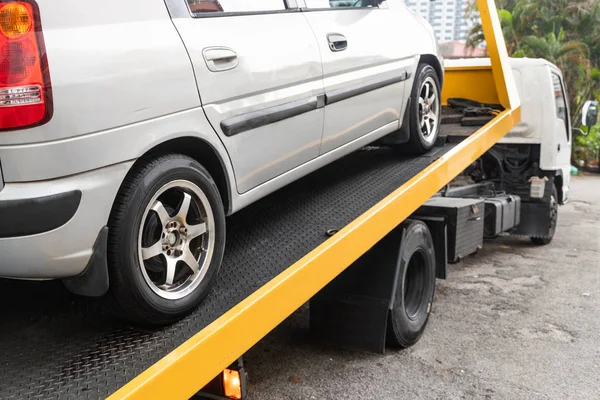 フックケーブル付きフラットベッドレッカー車に牽引された壊れた車 — ストック写真