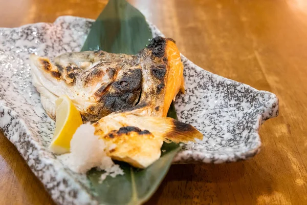 Grilled salmon fish head with lemon at Japanese restaurant — Stock Photo, Image