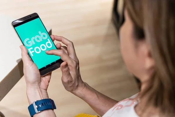 KUALA LUMPUR, MALAYSIA, 17 September 2019: Konseptual pemesanan makanan online melalui aplikasi Grabfood melalui telepon pintar. Grabfood adalah layanan pengiriman makanan dengan pertumbuhan tercepat di Asia . — Stok Foto