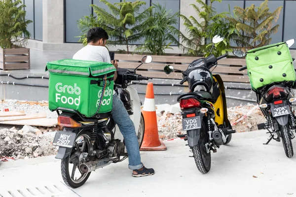 Kuala Lumpur, Malezya, 17 Eylül 2019: Gıda dağıtım hizmetleri ataması için restoranların dışında bekleyen grabfood sürücüleri. Grabfood Asya'da en hızlı büyüyen gıda dağıtım hizmeti sağlayıcısıdır. — Stok fotoğraf
