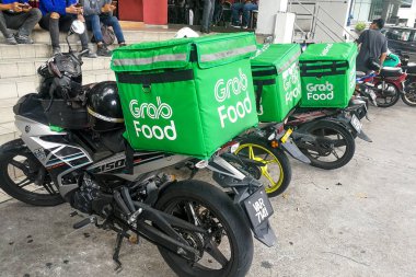 Kuala Lumpur, Malezya, 17 Eylül 2019: Gıda dağıtım hizmetleri ataması için restoranların dışında bekleyen grabfood sürücüleri. Grabfood Asya'da en hızlı büyüyen gıda dağıtım hizmeti sağlayıcısıdır.