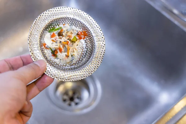 Filtro per lavello a mano con rifiuti alimentari intrappolati — Foto Stock