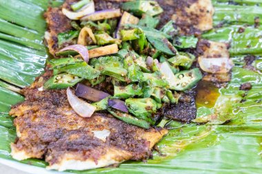Muz yaprağında Asya usulü baharatlı ızgara kokulu balık filetosu.