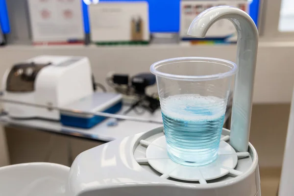 Mouth rinse in cup at dental clinic. Rinse before treatment for hygiene purpose.