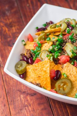 Bir tabak jalapeno, fasulye ve guacamole soslu lezzetli cips 