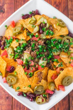 Bir tabak jalapeno, fasulye ve guacamole soslu lezzetli cips 