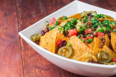 Bir tabak jalapeno, fasulye ve guacamole soslu lezzetli cips 