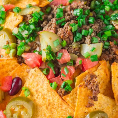 Bir tabak jalapeno, fasulye ve guacamole soslu lezzetli cips 