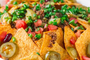 Bir tabak jalapeno, fasulye ve guacamole soslu lezzetli cips 