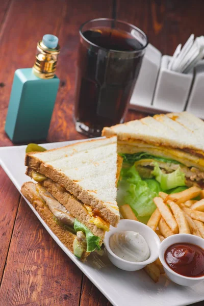 Club sandviç ile kızarmış patates ve ahşap arka plan üzerinde buharlaştırıcı