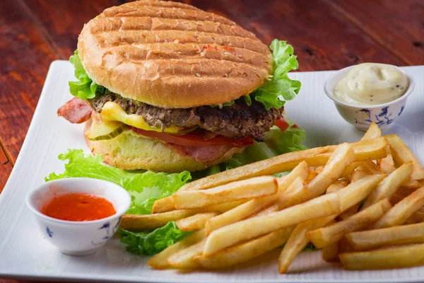 Hamburger ahşap arka plan üzerinde patates kızartması ile