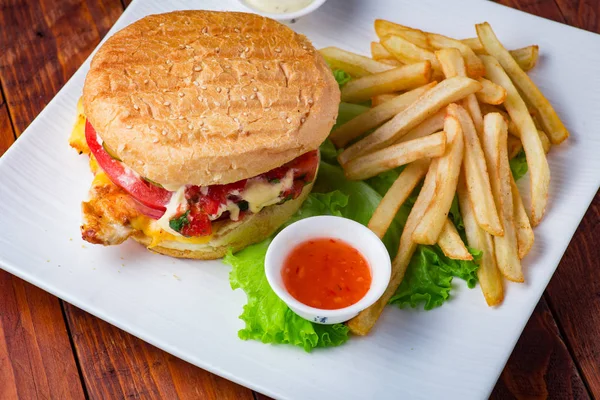 Hamburger ahşap arka plan üzerinde patates kızartması ile