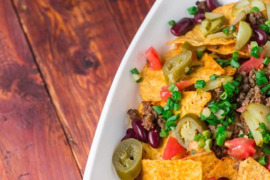 Bir tabak jalapeno, fasulye ve guacamole soslu lezzetli cips 