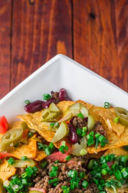 Bir tabak jalapeno, fasulye ve guacamole soslu lezzetli cips 