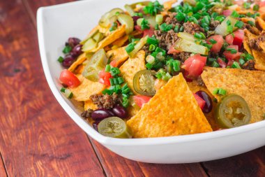 Bir tabak jalapeno, fasulye ve guacamole soslu lezzetli cips 