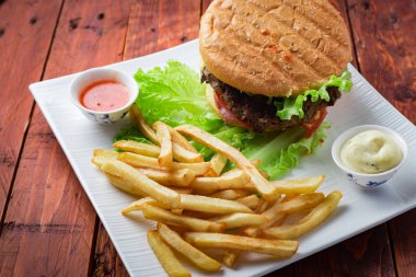 Hamburger ahşap arka plan üzerinde patates kızartması ile