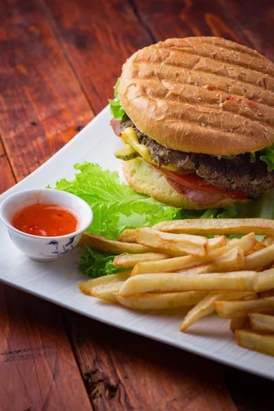 Hamburger ahşap arka plan üzerinde patates kızartması ile