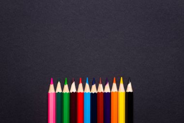 Siyah arkaplanda renkli kalemler