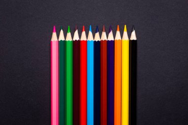 Siyah arkaplanda renkli kalemler