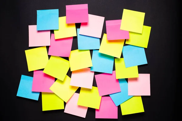 Many colorful sticky notes on black background