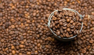 Kahve çekirdekleri arka planda oyuncak metal kova