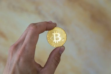 adamın elinde altın bitcoin